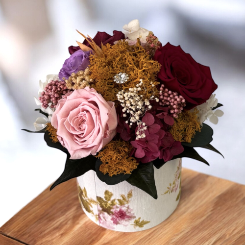 Menšia kytica farebných stabilizovaných kvetov vo flower boxe v 